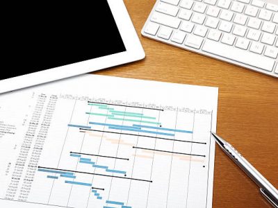 Working desk with gantt chart , computer tablet and keyboard